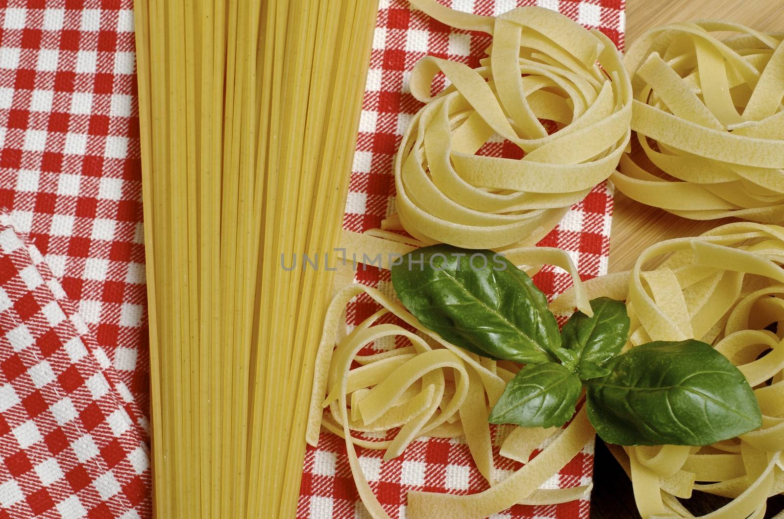 Raw pasta with basil leaf on kitchen towel
