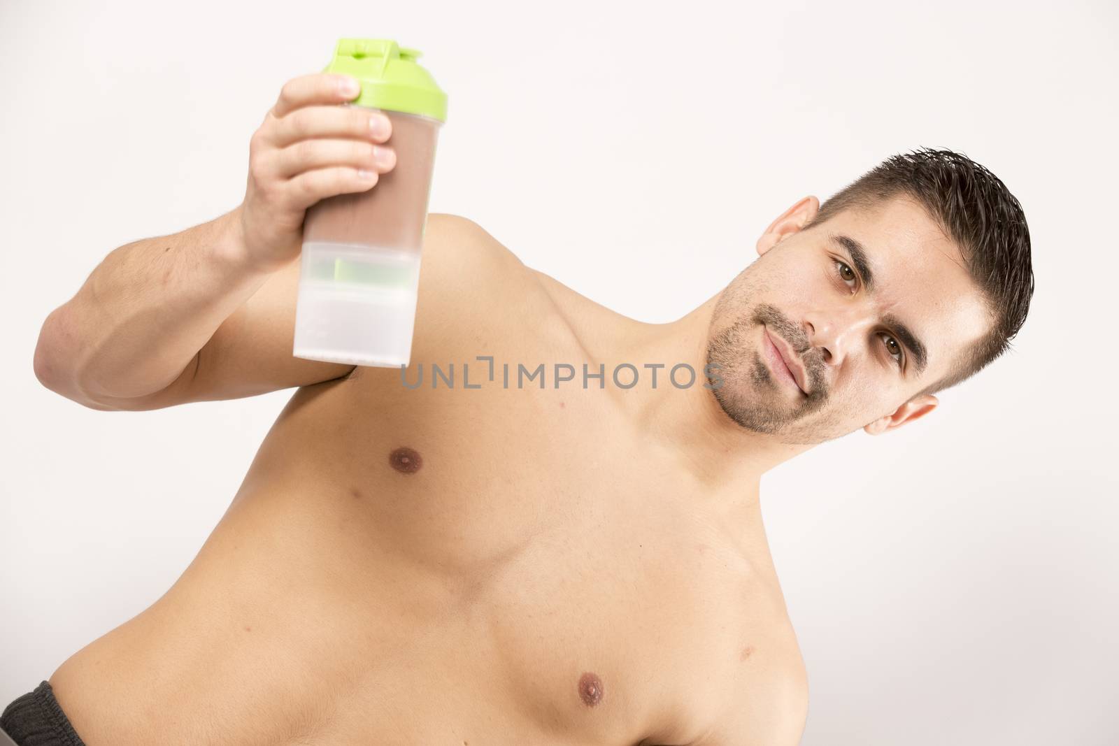 athletic beautiful man with protein shake bottle by CatherineL-Prod