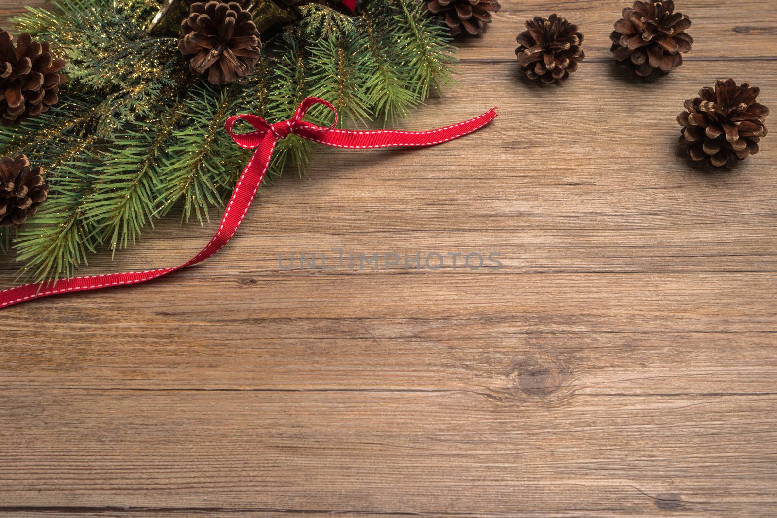 Christmas border design with pine cone, fir branches and ribbon over old oak wood