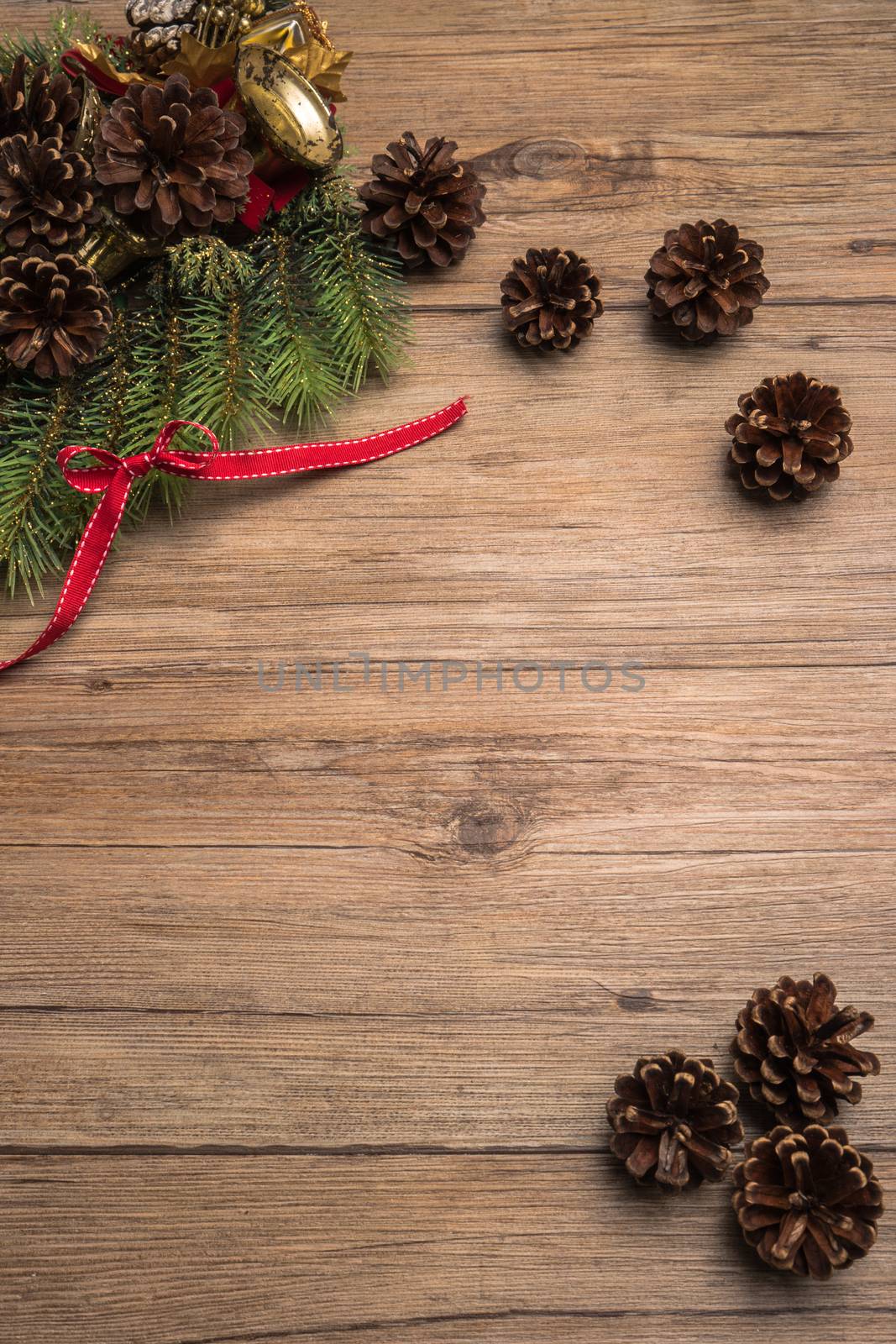 Christmas border design with pine cone, fir branches and ribbon over old oak wood