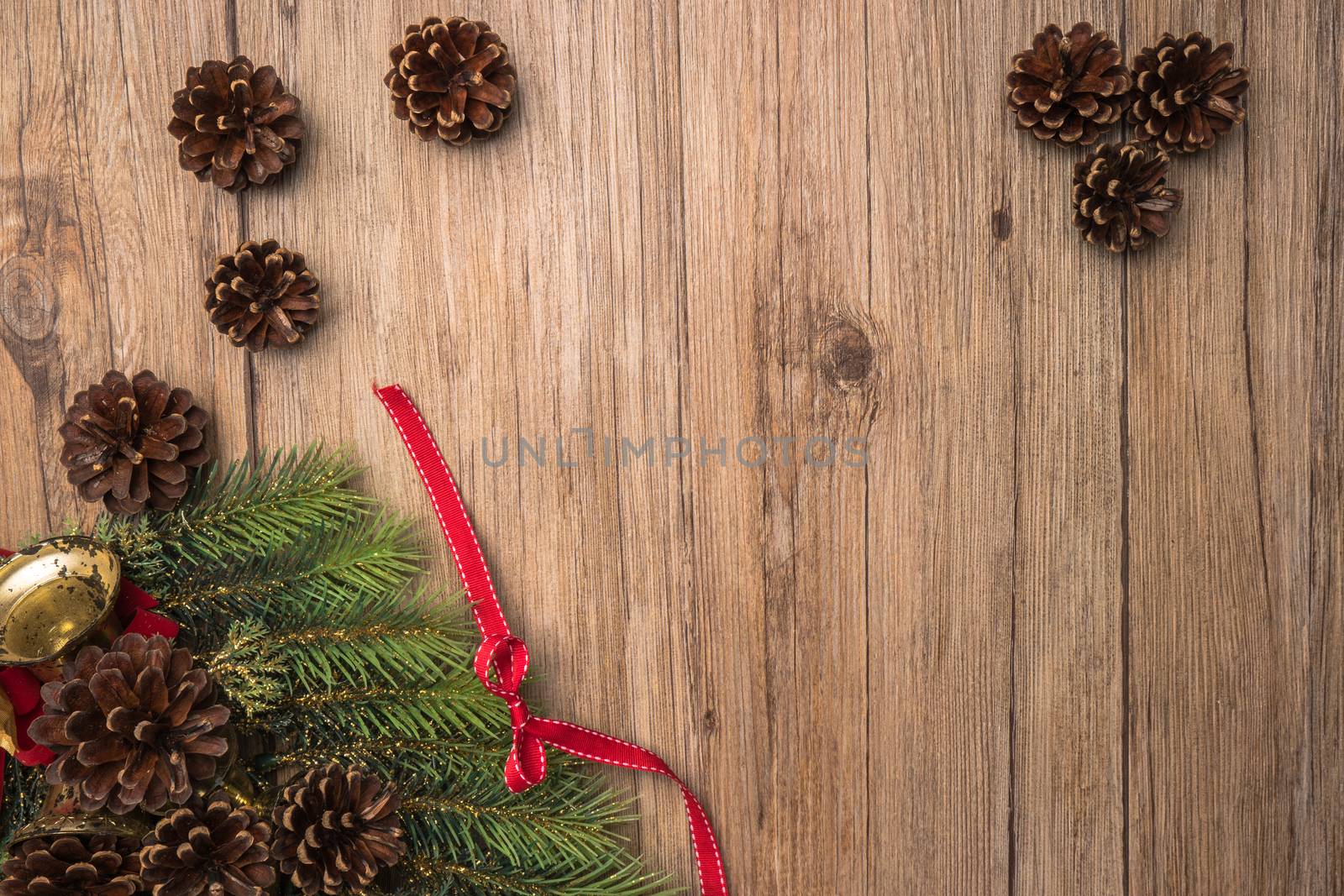 Christmas border design with pine cone, fir branches and ribbon over old oak wood