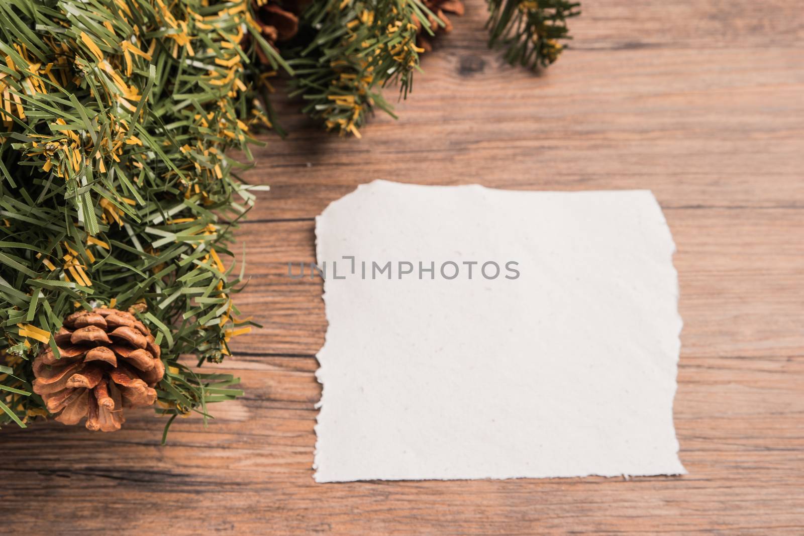 Christmas border design with pine cone and fir branches on parchment paper over old oak wood