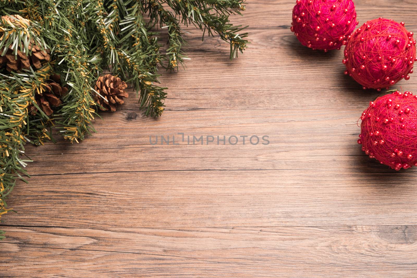 Christmas border design with pine cone, fir branches and christmas balls over old oak wood
