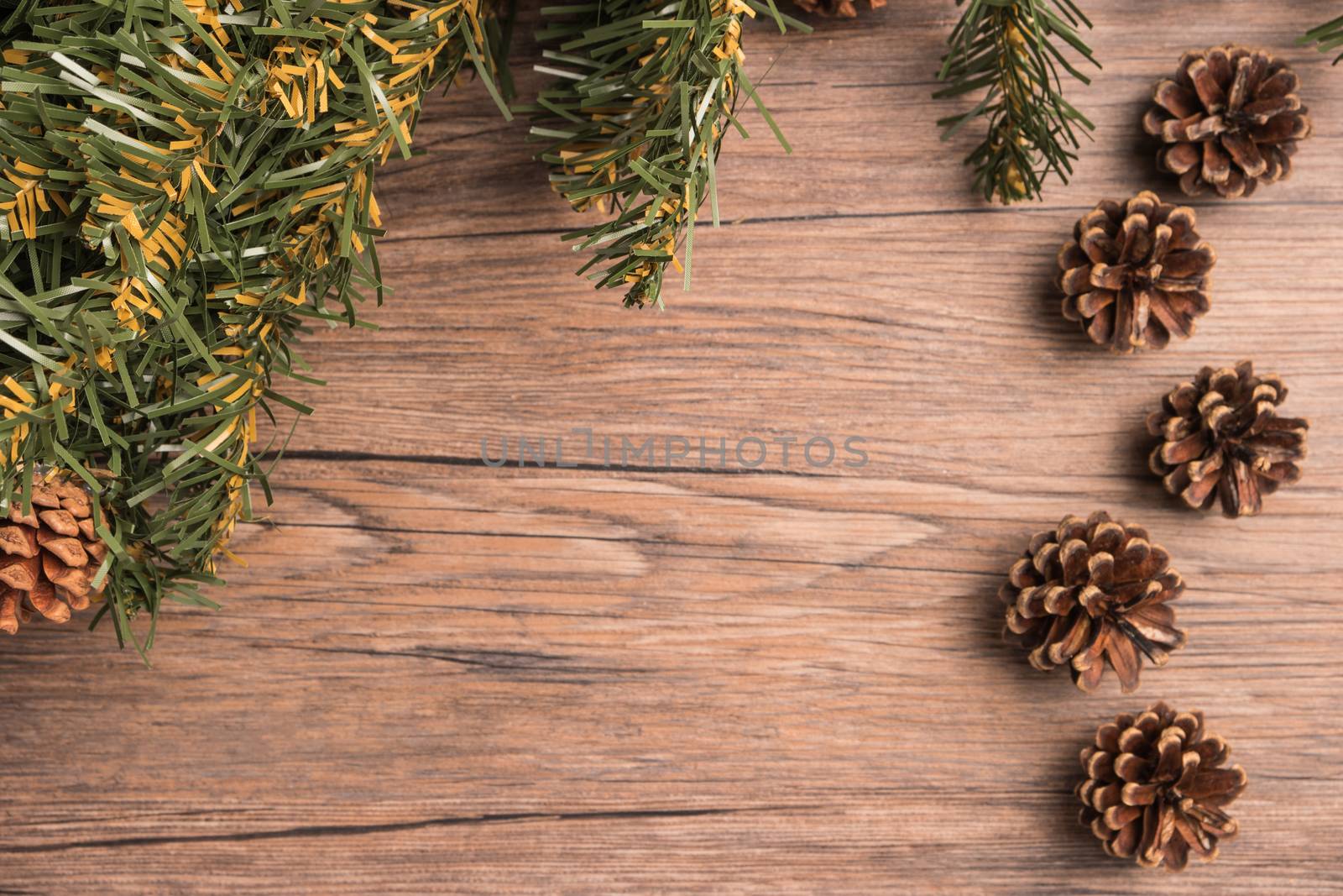 Christmas border design with pine cone and fir branches over old oak wood