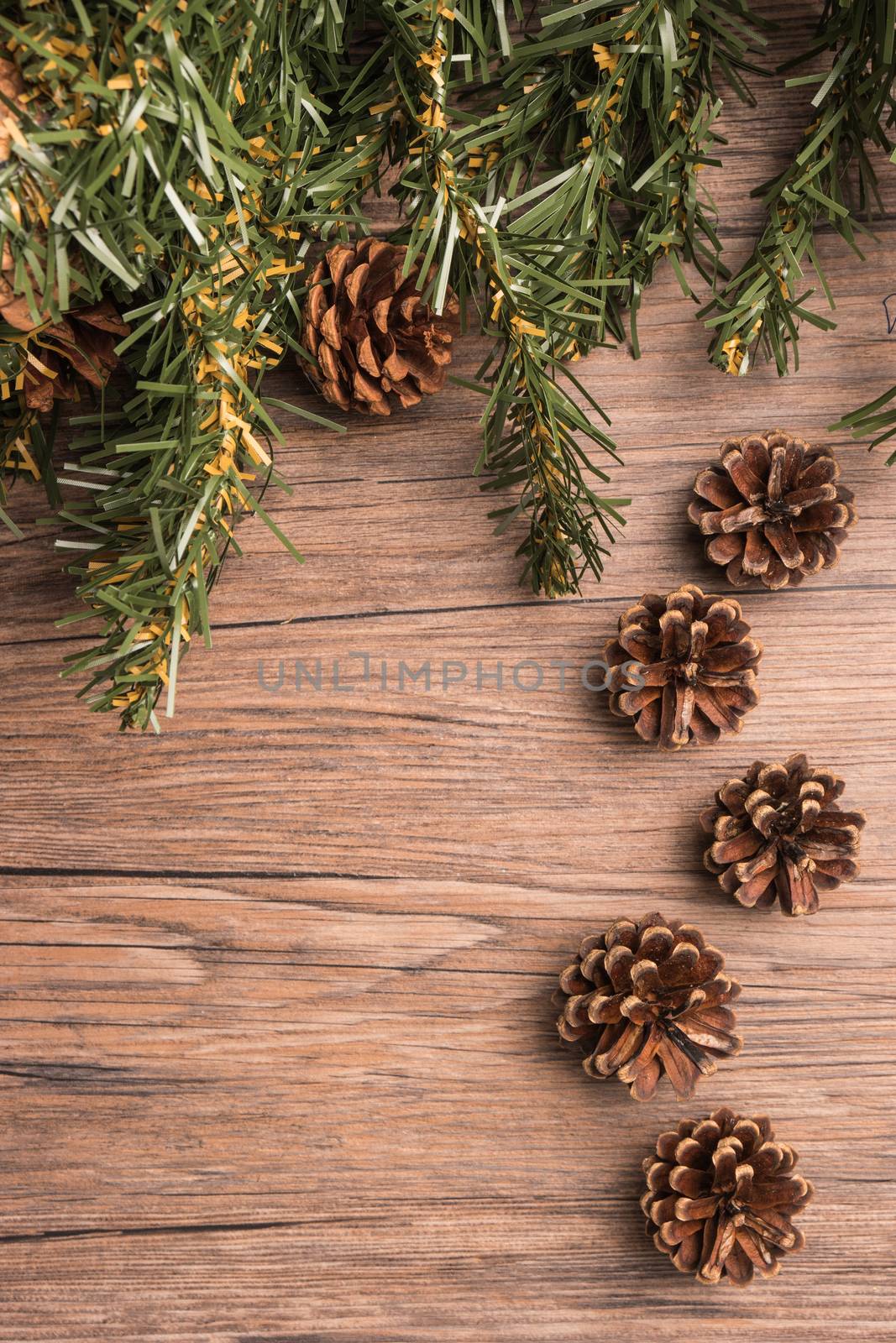 Christmas border design with pine cone and fir branches over old oak wood