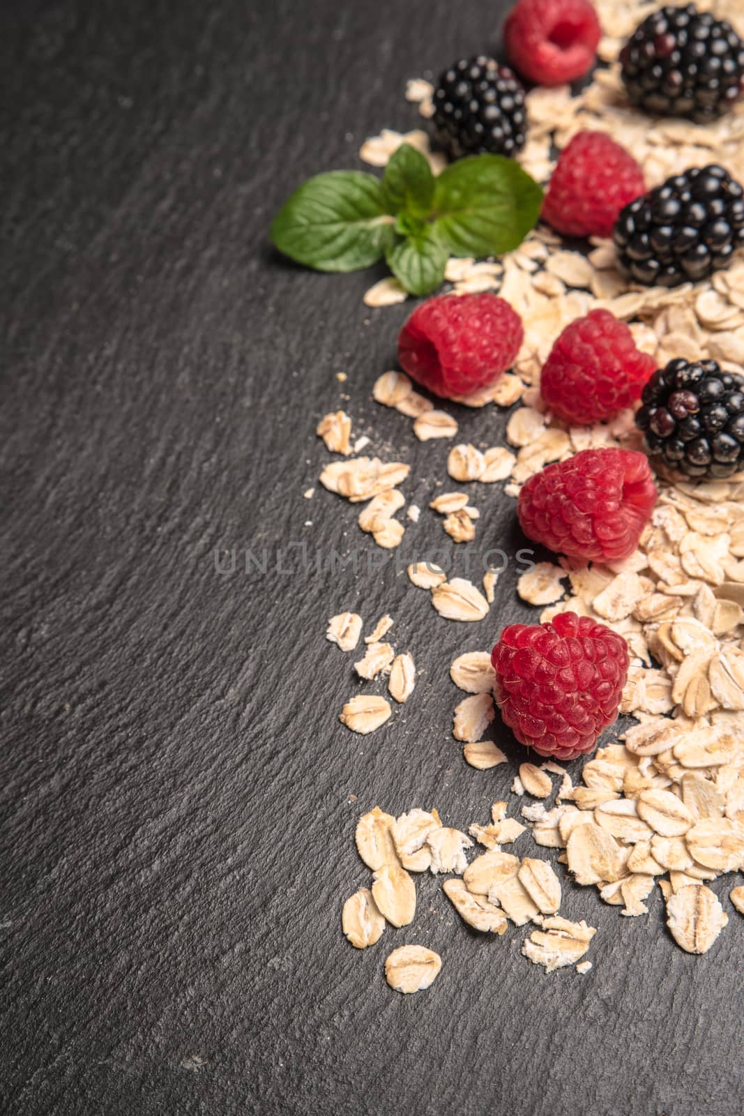 Healthy breakfast and berries on slate background, close-up by AnaMarques