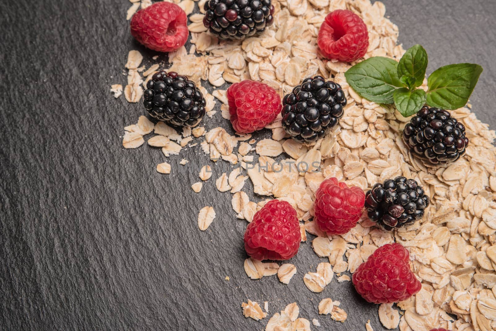 Healthy breakfast and berries on slate background, close-up by AnaMarques