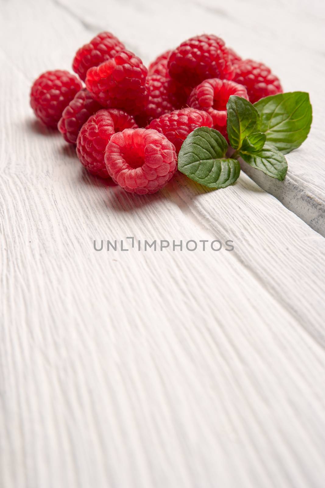Ripe sweet raspberries on wood table background