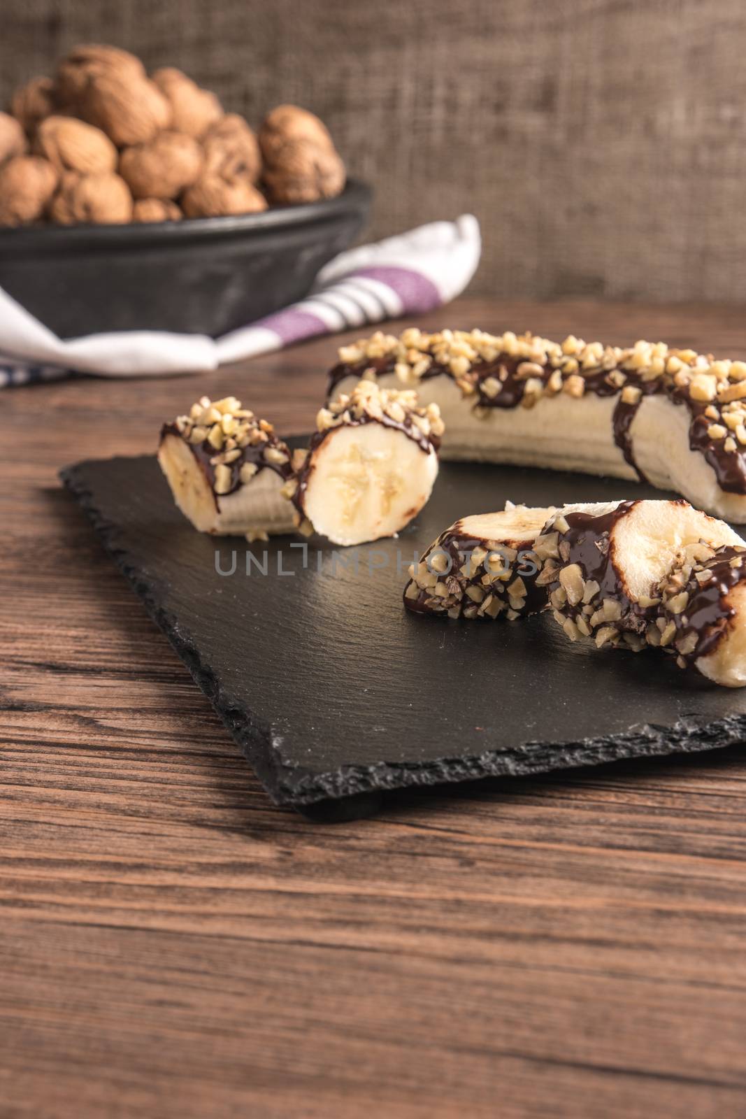 Fresh banana with melted chocolate and nuts coverage by AnaMarques
