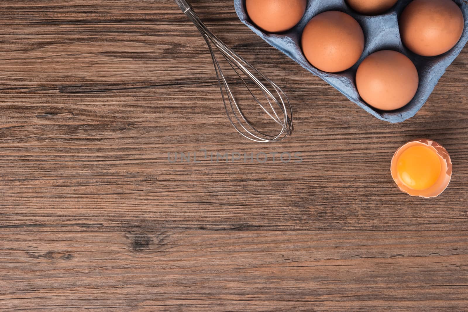 Cardboard egg box on wooden table. Top view with copy space by AnaMarques