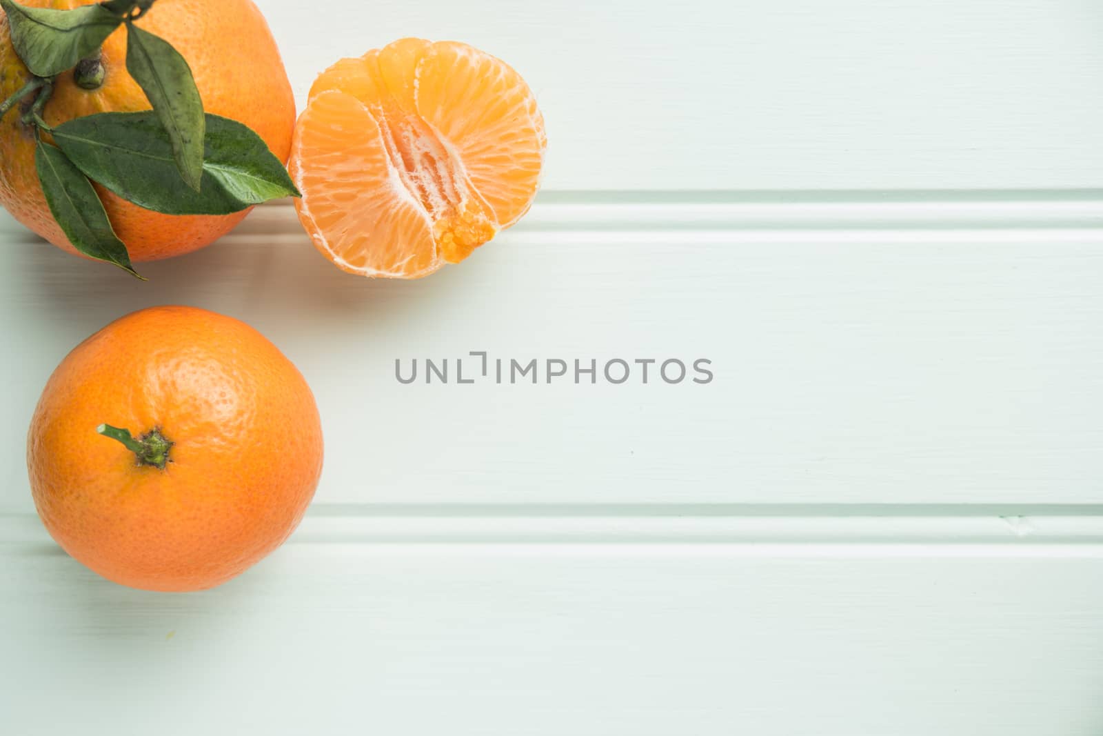 Fresh clementines on wooden board with leaves. Top view with copy space.