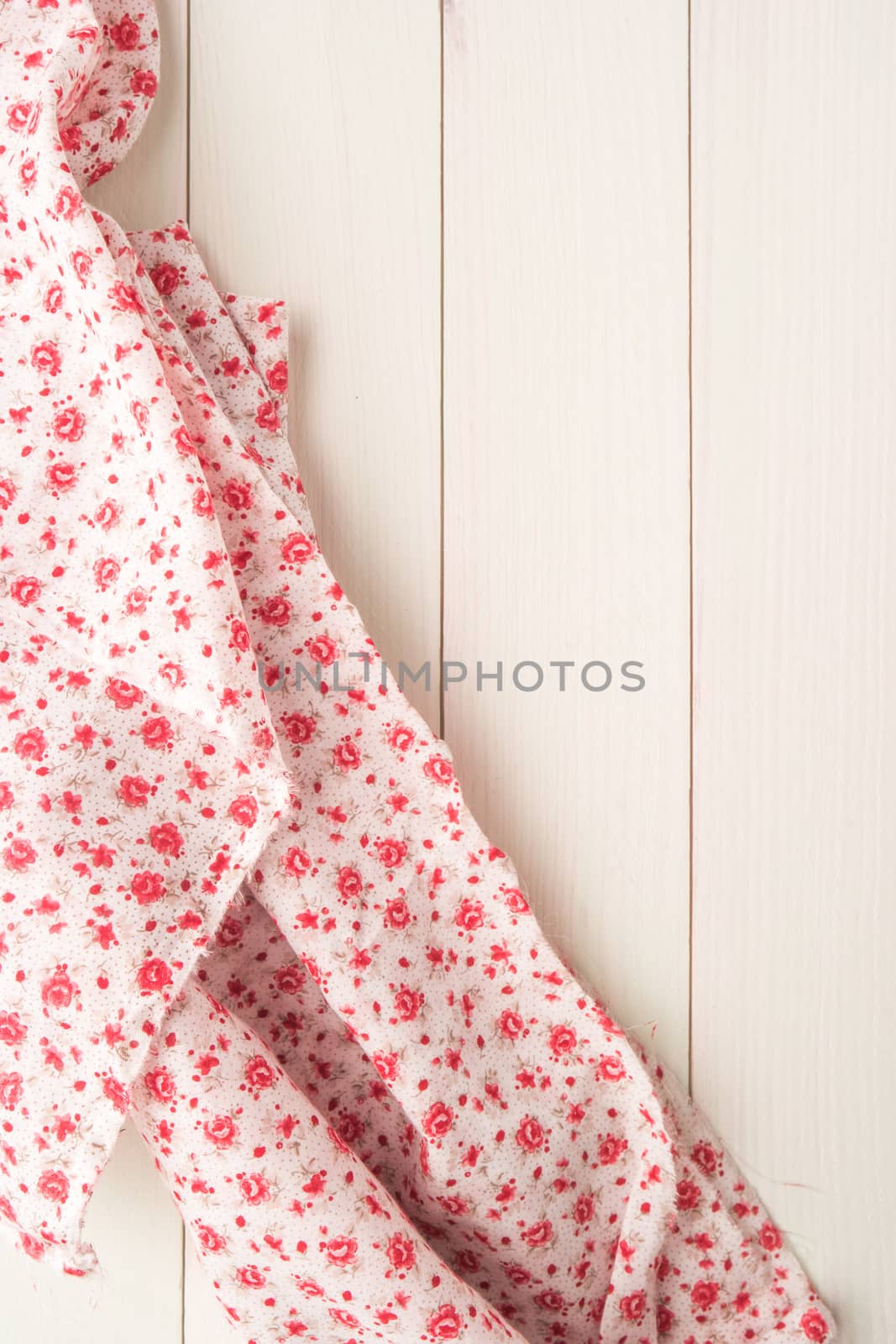 Little flowers fabric over wooden kitchen table. Top of view with copy space