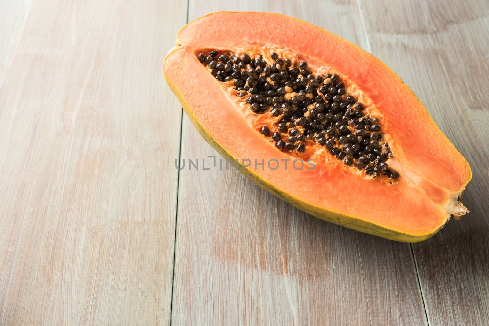 Sliced fresh papaya on wooden background. Top view with copy spa by AnaMarques