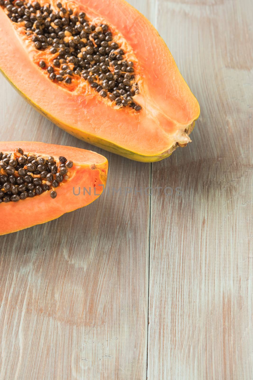 Sliced fresh papaya on wooden background. Top view with copy spa by AnaMarques