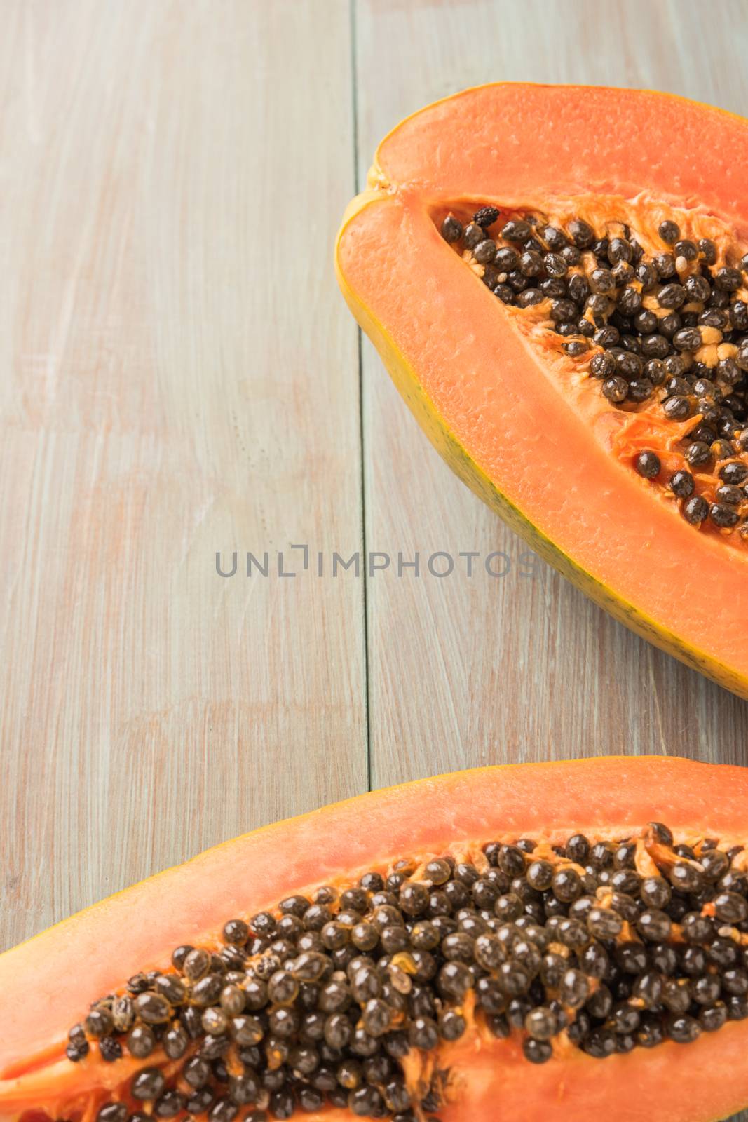 Sliced fresh papaya on wooden background. Top view with copy spa by AnaMarques