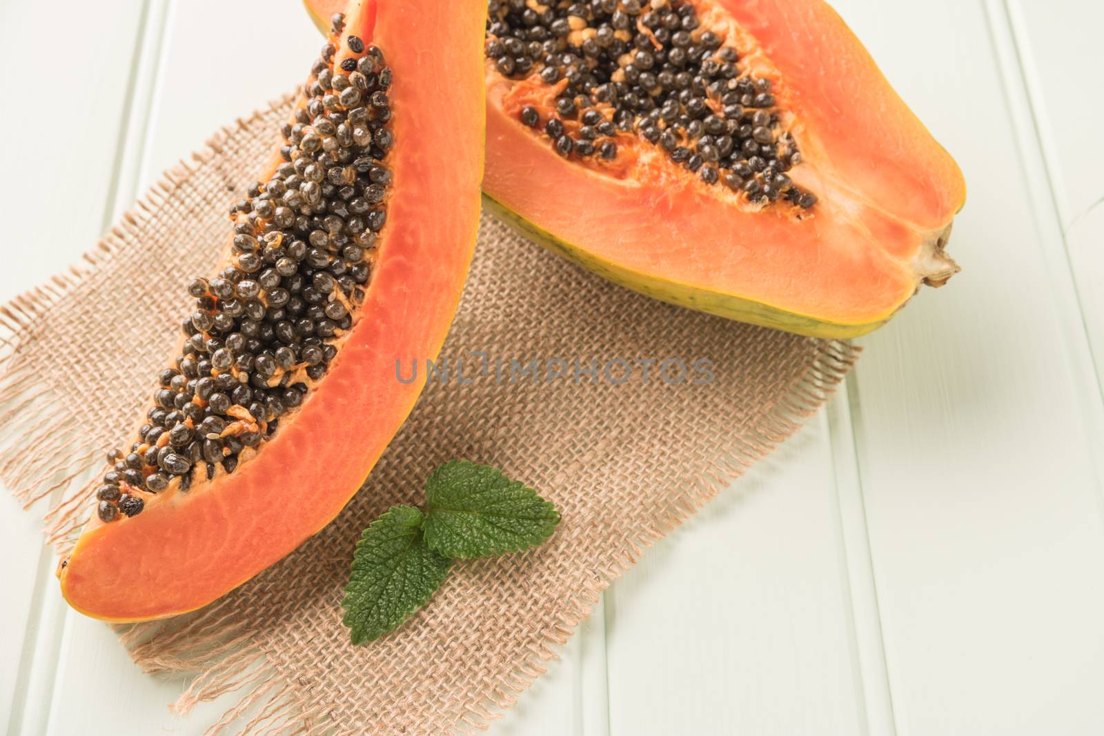 Sliced fresh papaya on wooden background. Top view with copy space