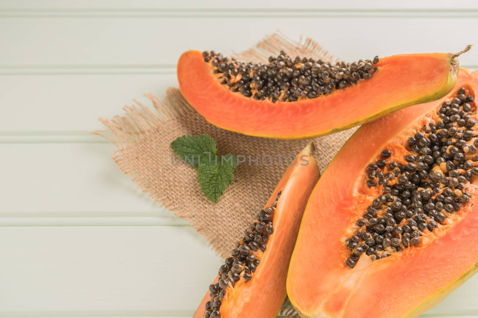 Sliced fresh papaya on wooden background. Top view with copy spa by AnaMarques