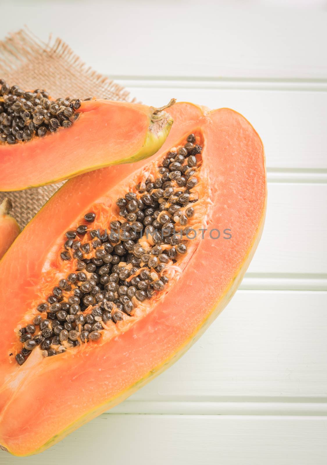 Sliced fresh papaya on wooden background. Top view with copy spa by AnaMarques