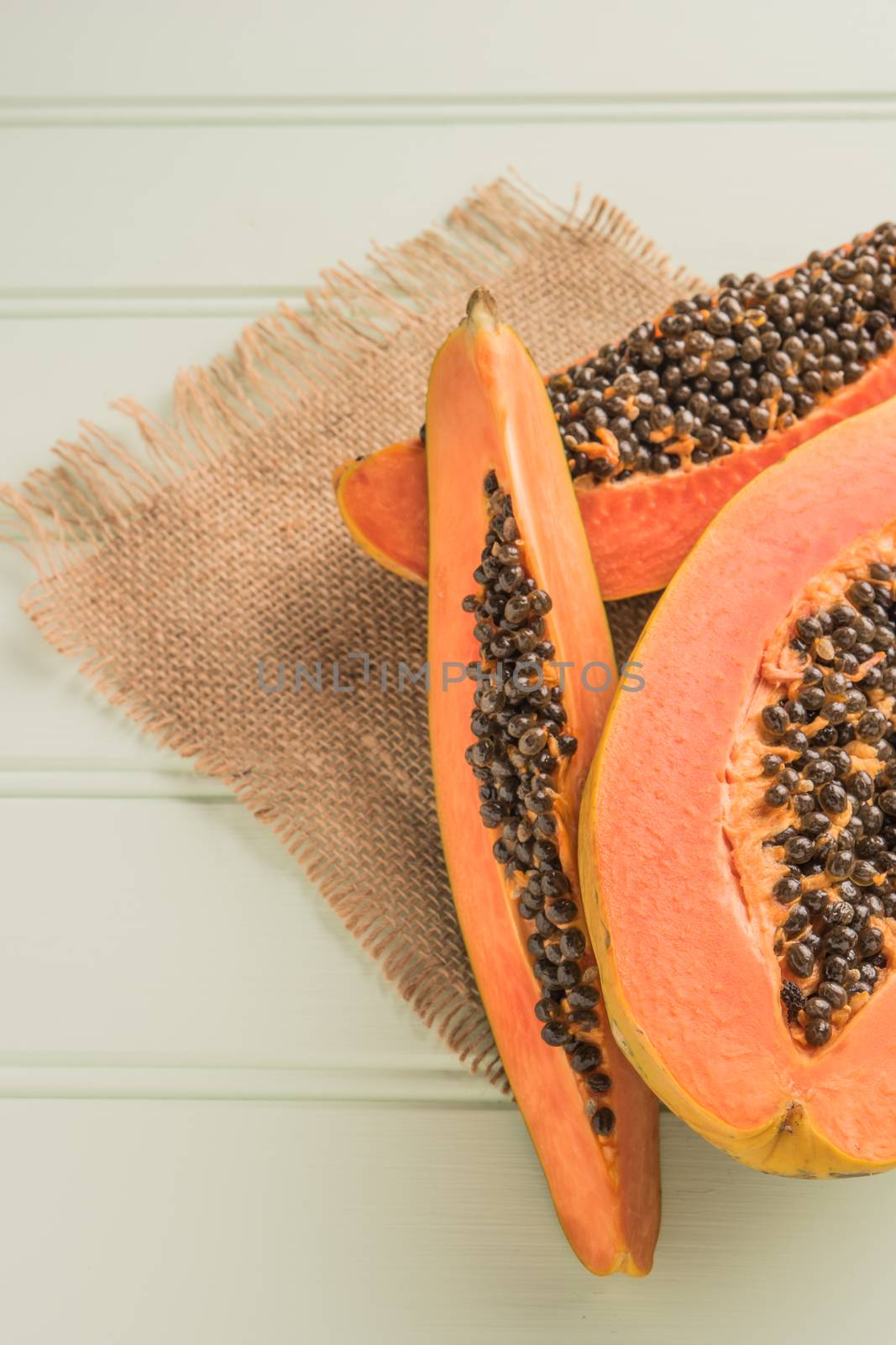 Sliced fresh papaya on wooden background. Top view with copy spa by AnaMarques