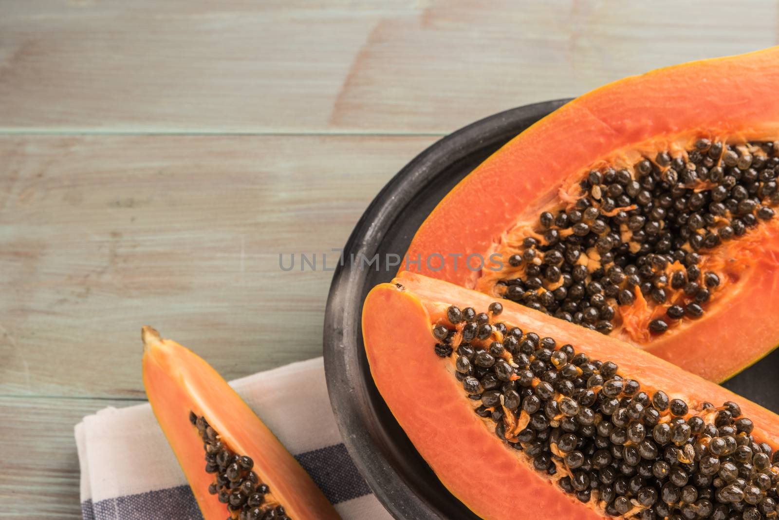 Sliced fresh papaya on wooden background. Top view with copy spa by AnaMarques