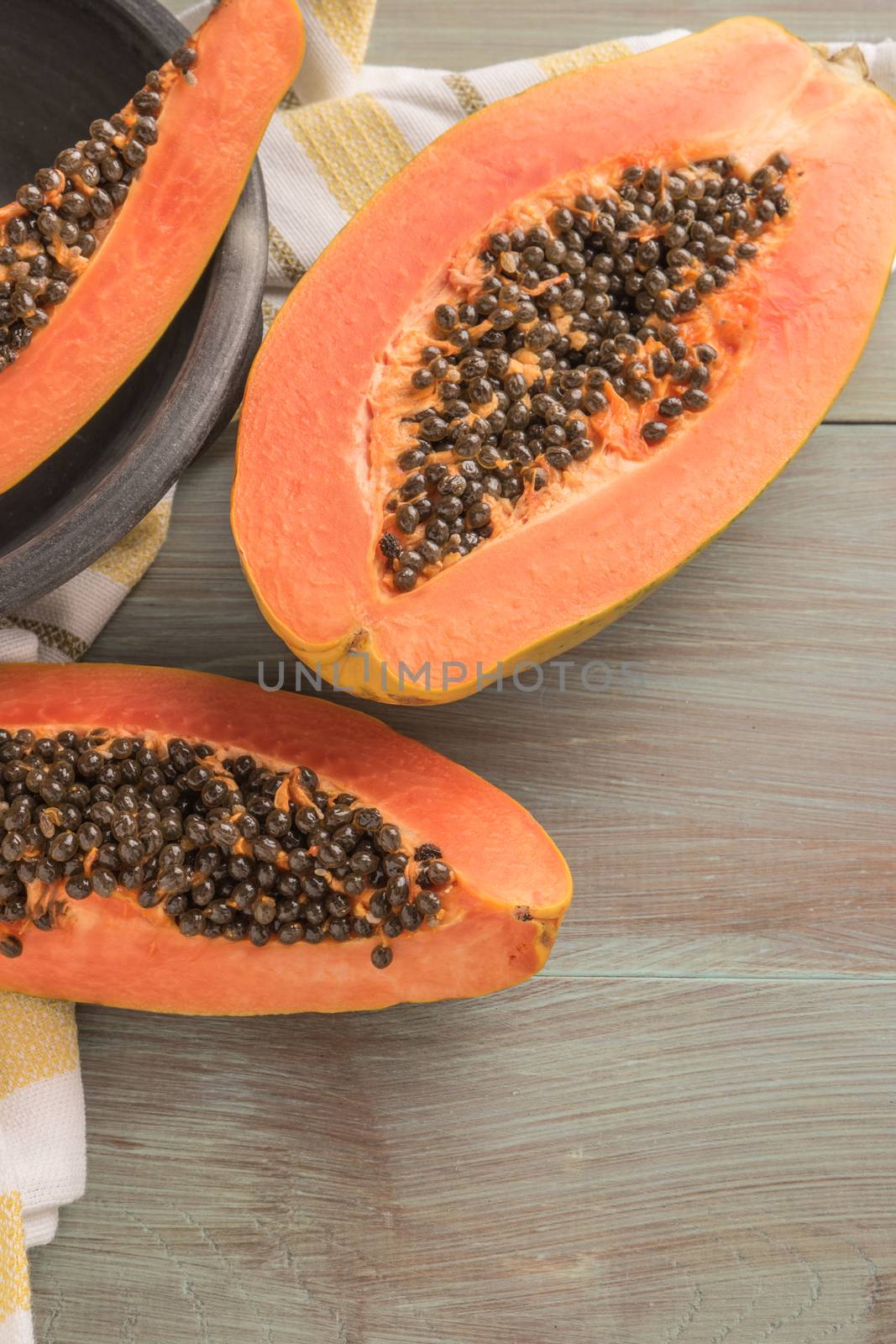 Sliced fresh papaya on wooden background. Top view with copy space