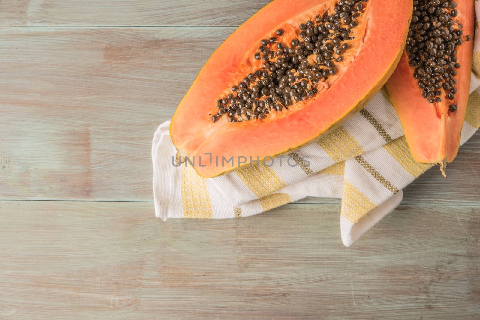 Sliced fresh papaya on wooden background. Top view with copy space