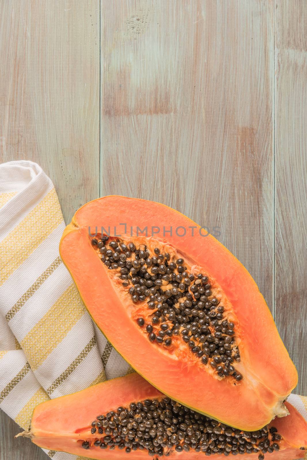 Sliced fresh papaya on wooden background. Top view with copy spa by AnaMarques