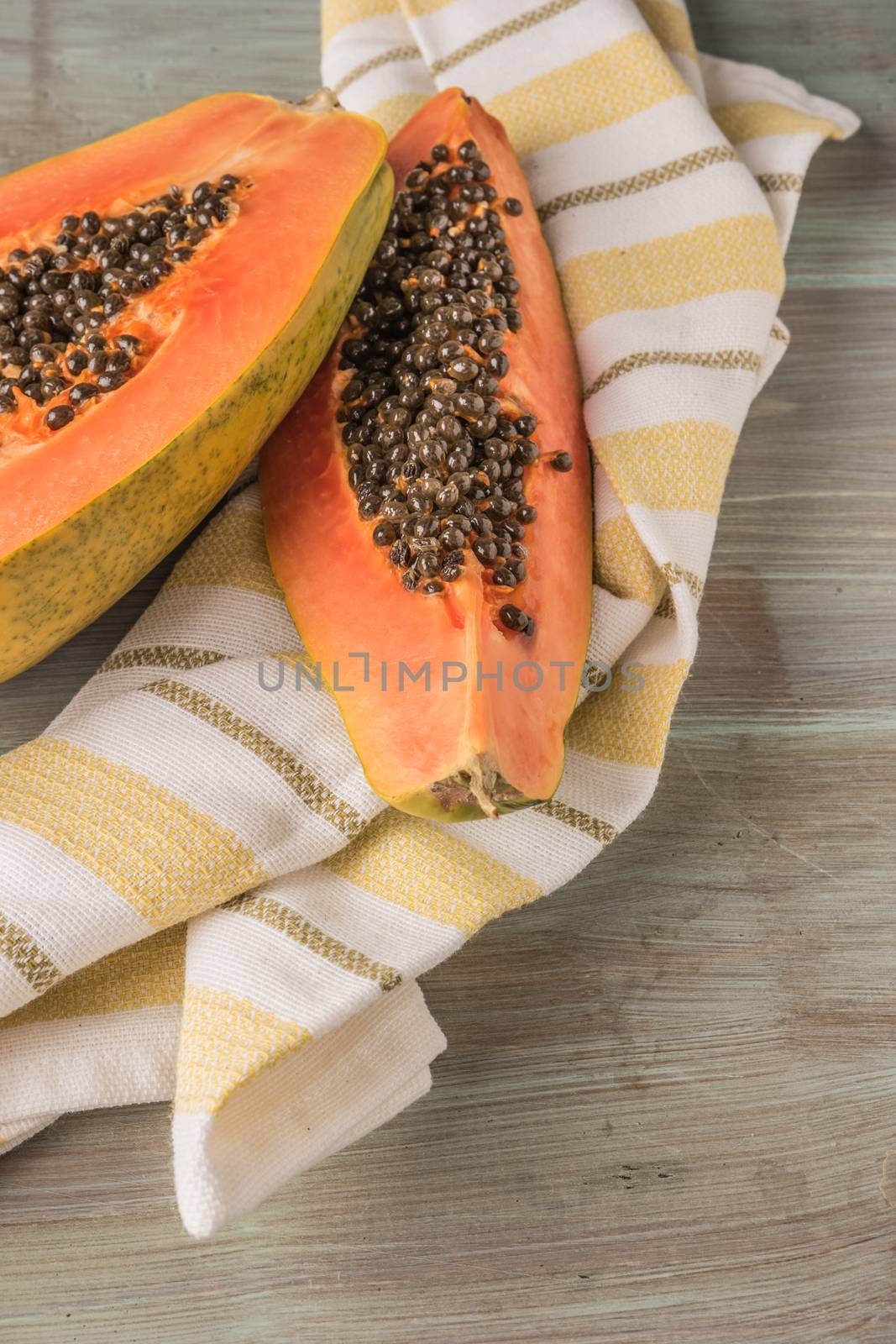 Sliced fresh papaya on wooden background. Top view with copy spa by AnaMarques