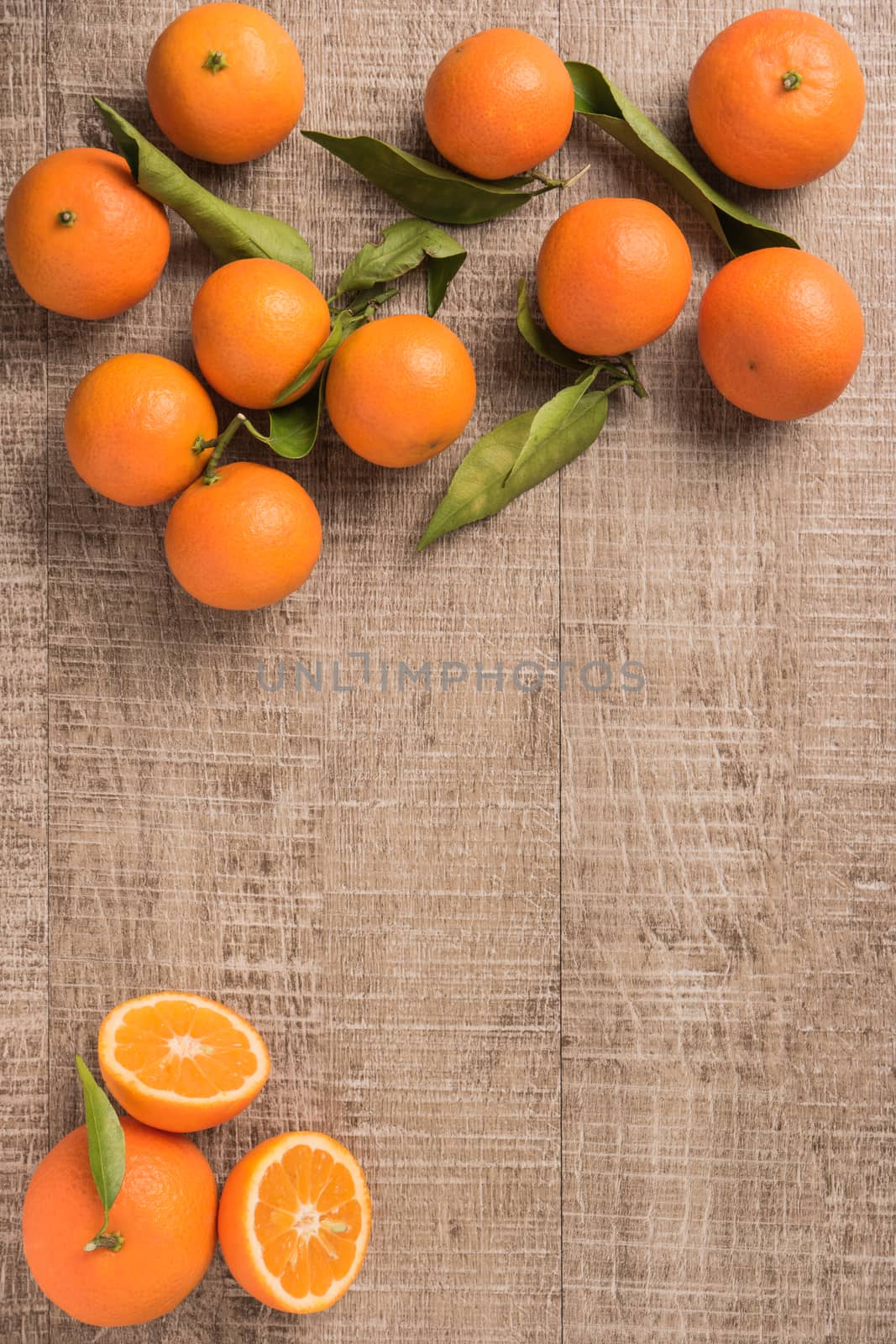 Fresh clementines on wooden board with leaves. Top view with copy space.