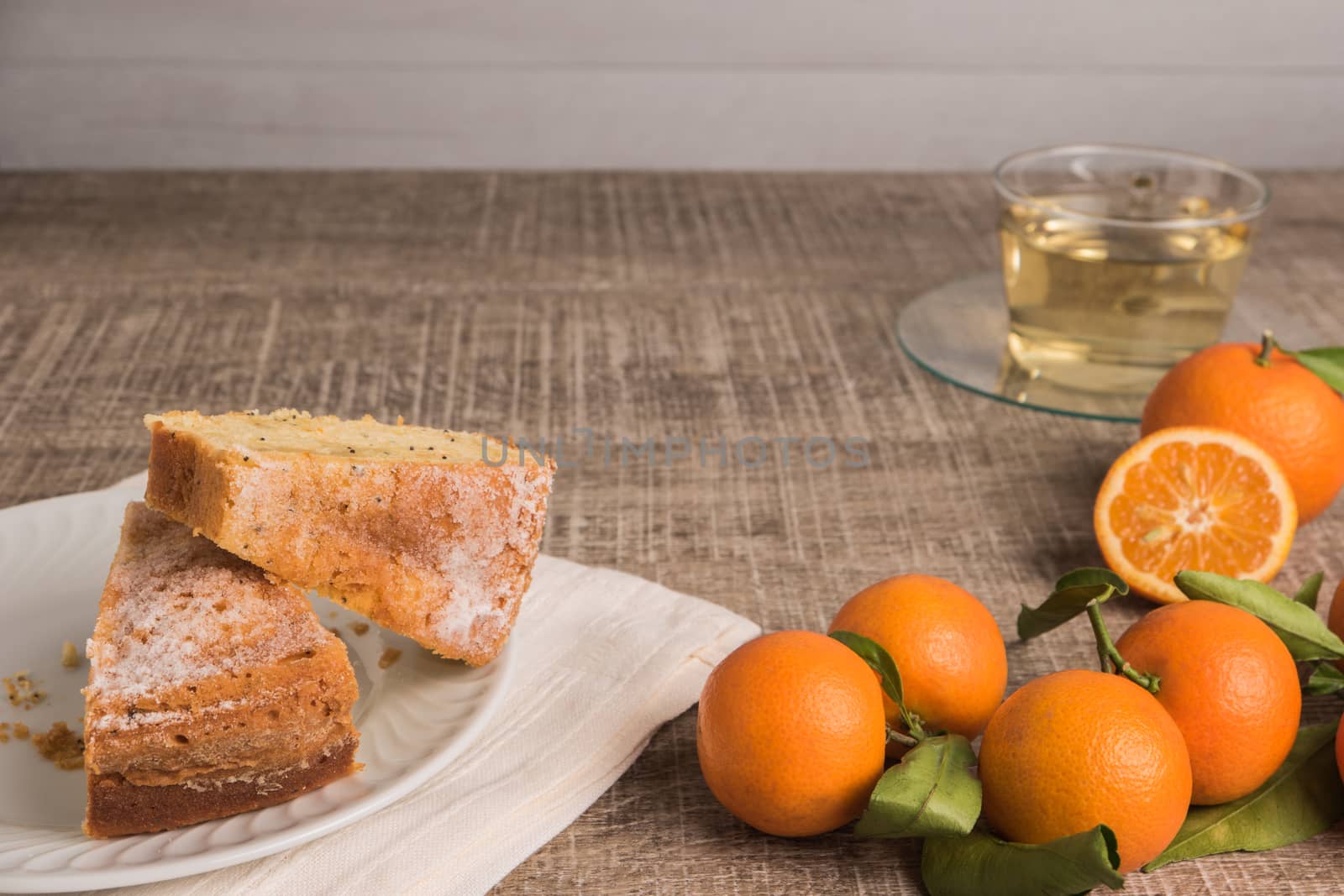 Slices of clementine cake with powdered sugar topping and cup of by AnaMarques