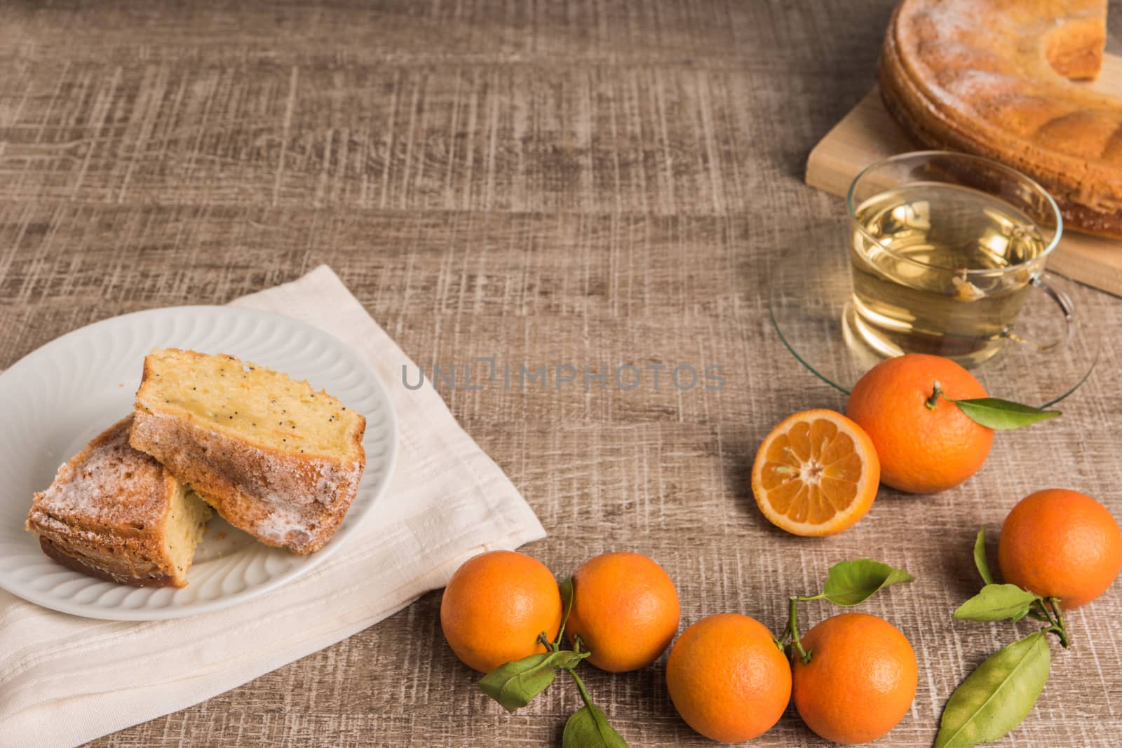 Slices of clementine cake with powdered sugar topping and cup of by AnaMarques