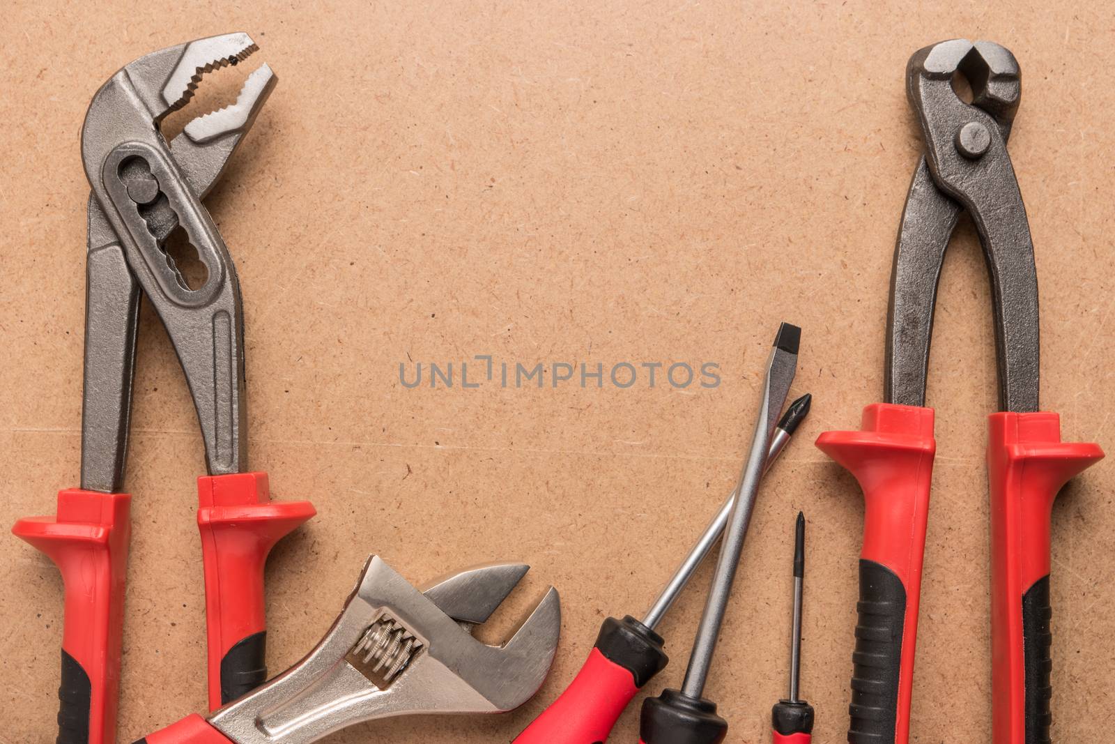 Set of pump plier, plier, screwdrivers and wrenches. Tools over a wood panel. Top view with copy space.