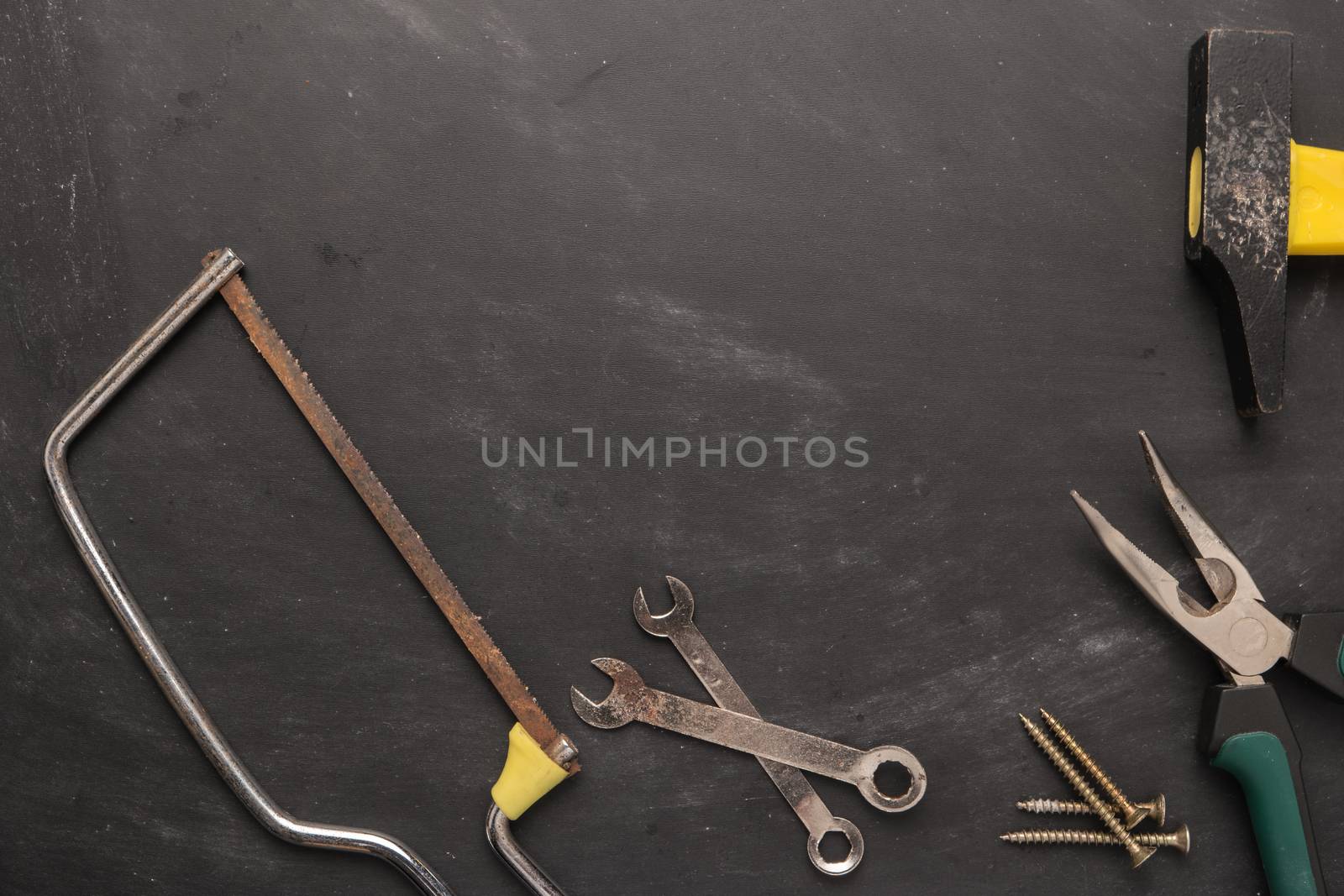 Set of saw, plier, screw and hammer. Tools over a wood panel. To by AnaMarques