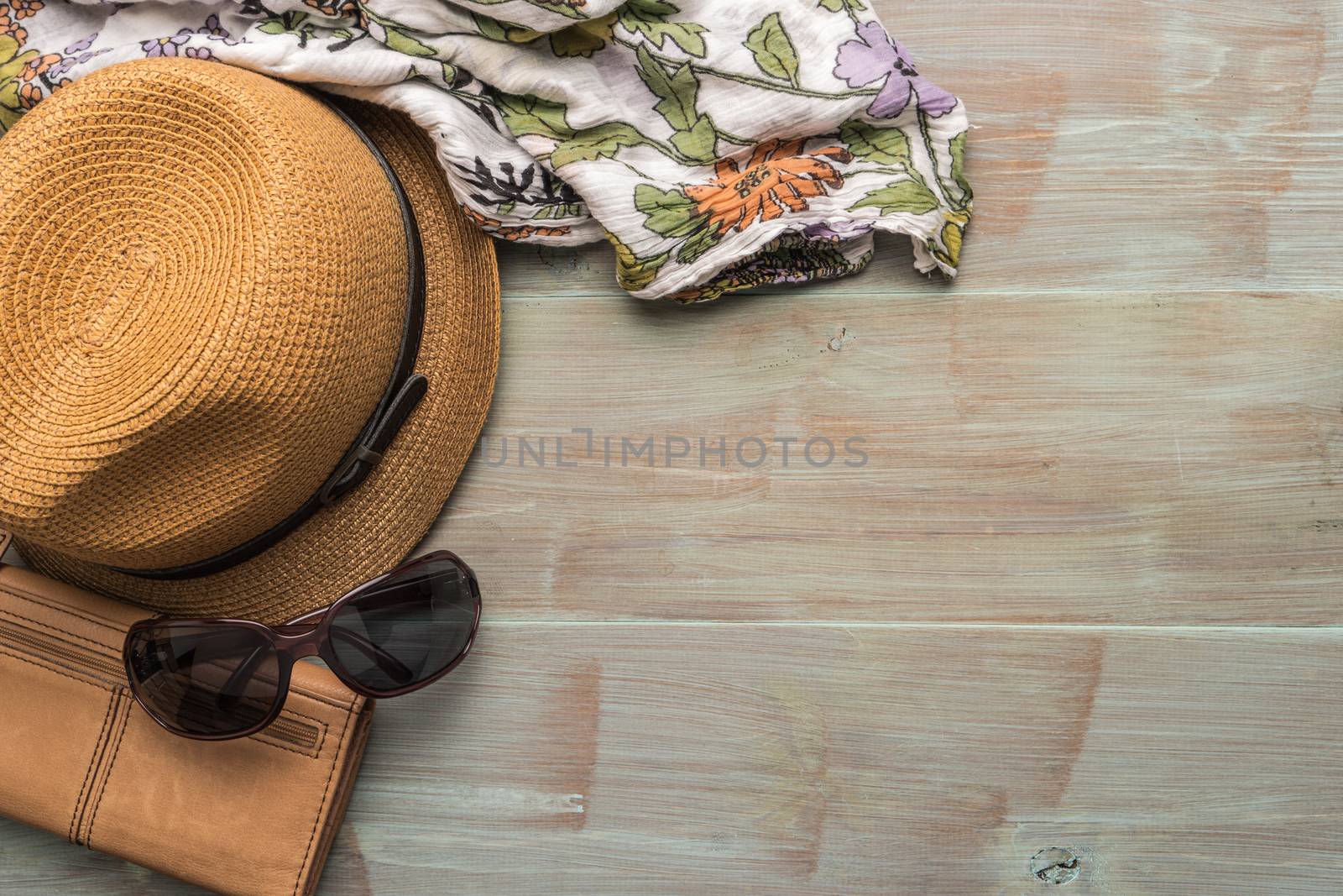 Travel, summer vacation, tourism and objects concept - close up of hat, wallet, sunglasses and scarf on wooden table. Top view with copy space.