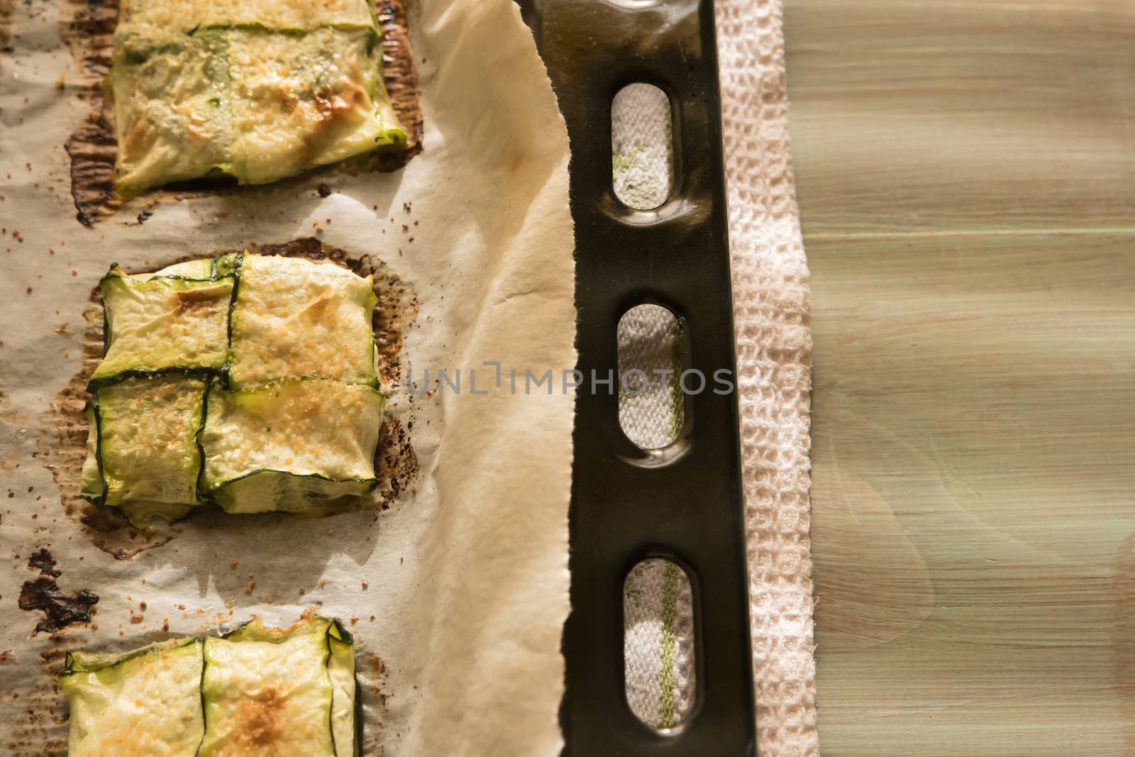 Oven baked courgettes stuffed with cheese, garlic and herbs. Courgette recipe in the oven. Top view with copy space.