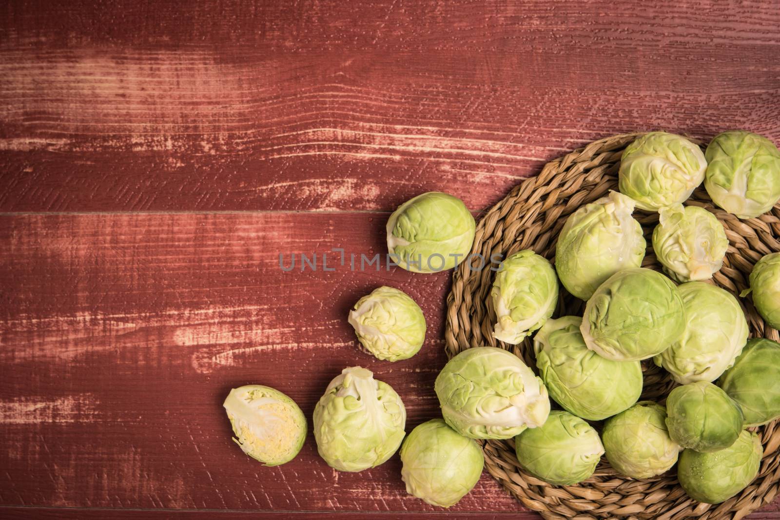 Fresh brussel sprouts over rustic wooden texture. Top view with copy space.