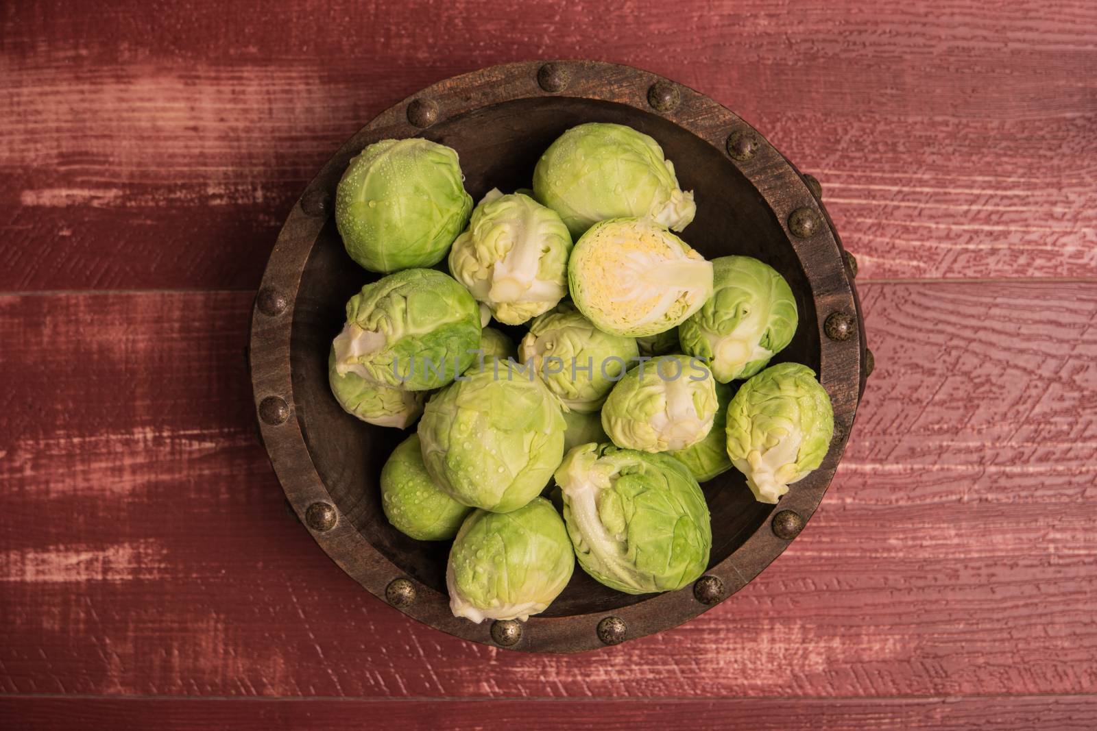 Fresh brussel sprouts over rustic wooden texture. Top view with copy space.