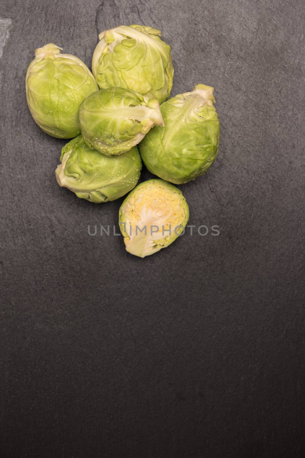 Fresh brussel sprouts on slate. Top view with copy space. by AnaMarques
