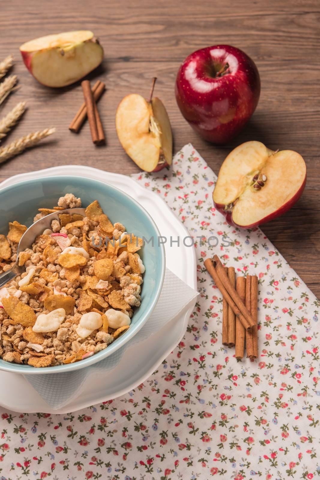 Healthy breakfast with muesli, red apple and cinnamon on rustic wooden table. Top view with copy space.