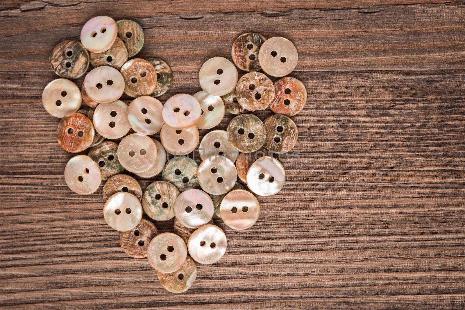 Valentine heart buttons textilesover rustic wooden texture. Top view with copy space.