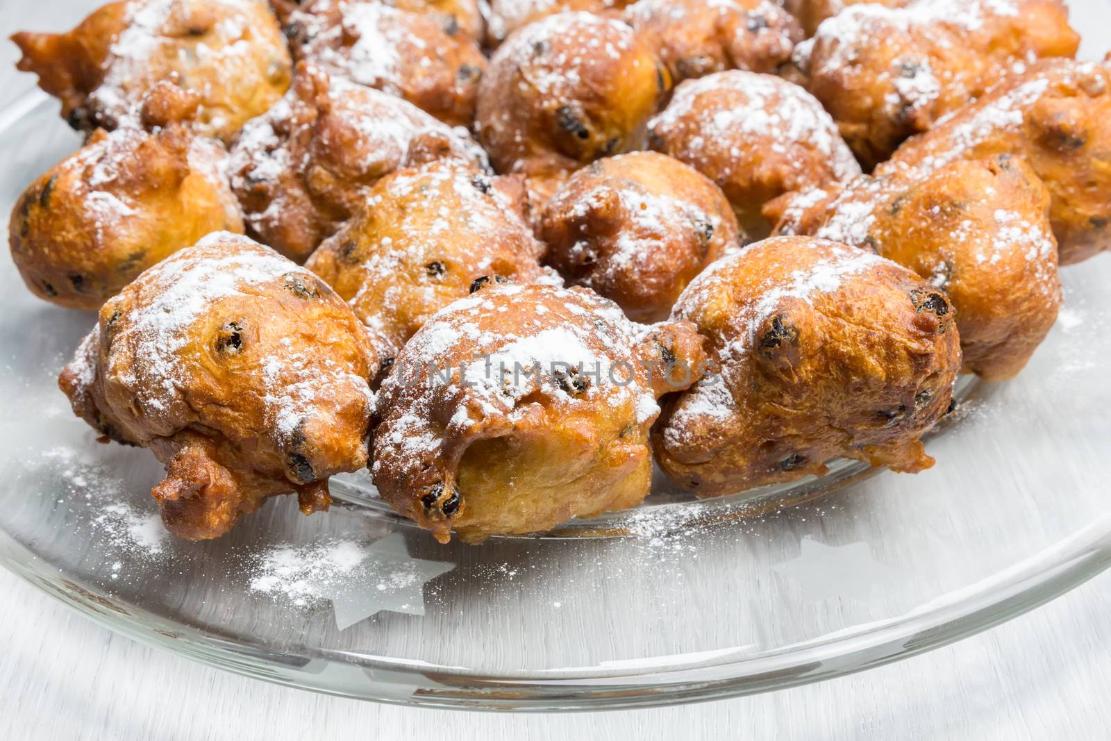 Many turnovers or oliebollen with icing sugar on scale by BenSchonewille