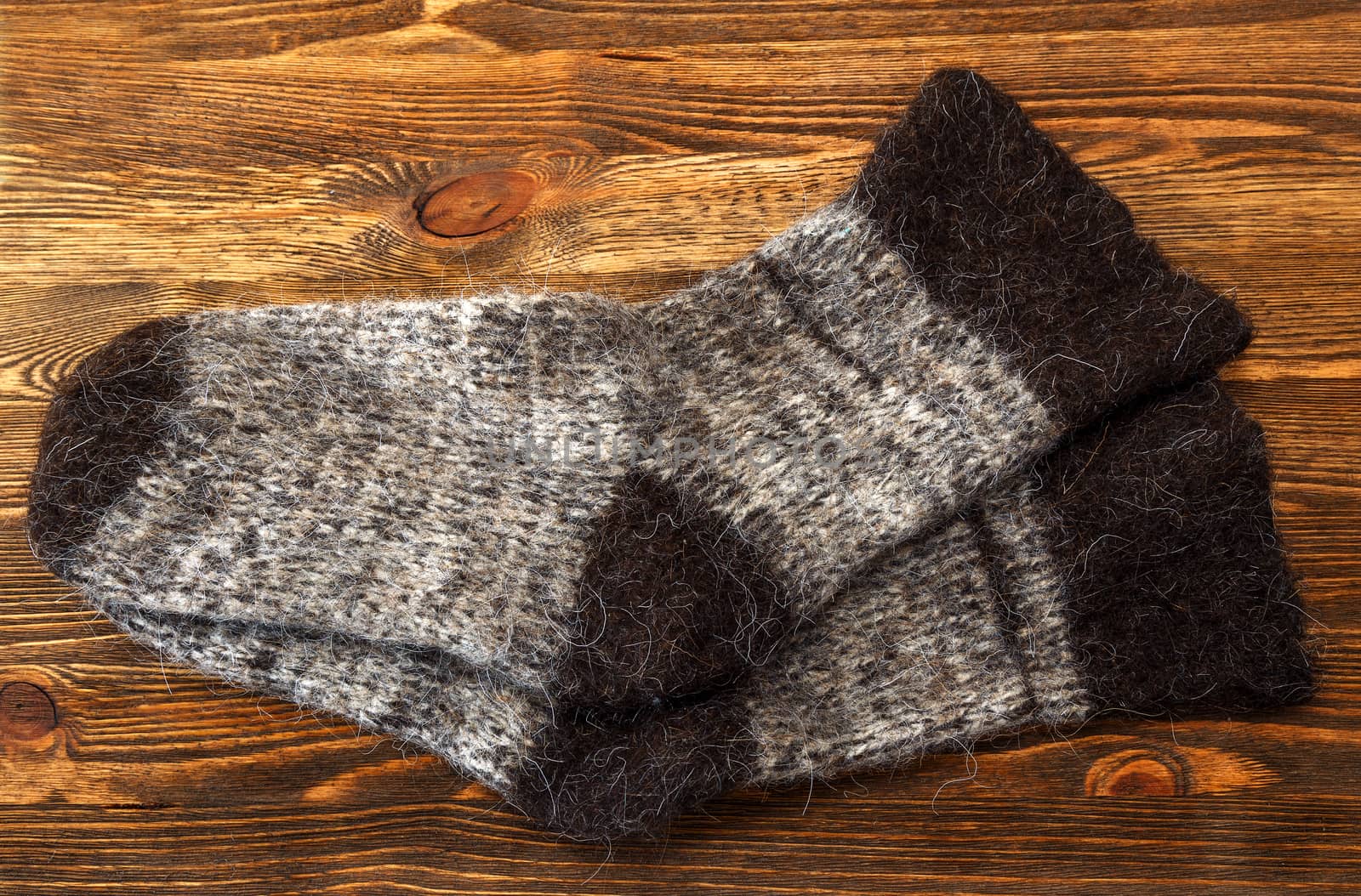 Knitted wool socks on a brown wooden background
