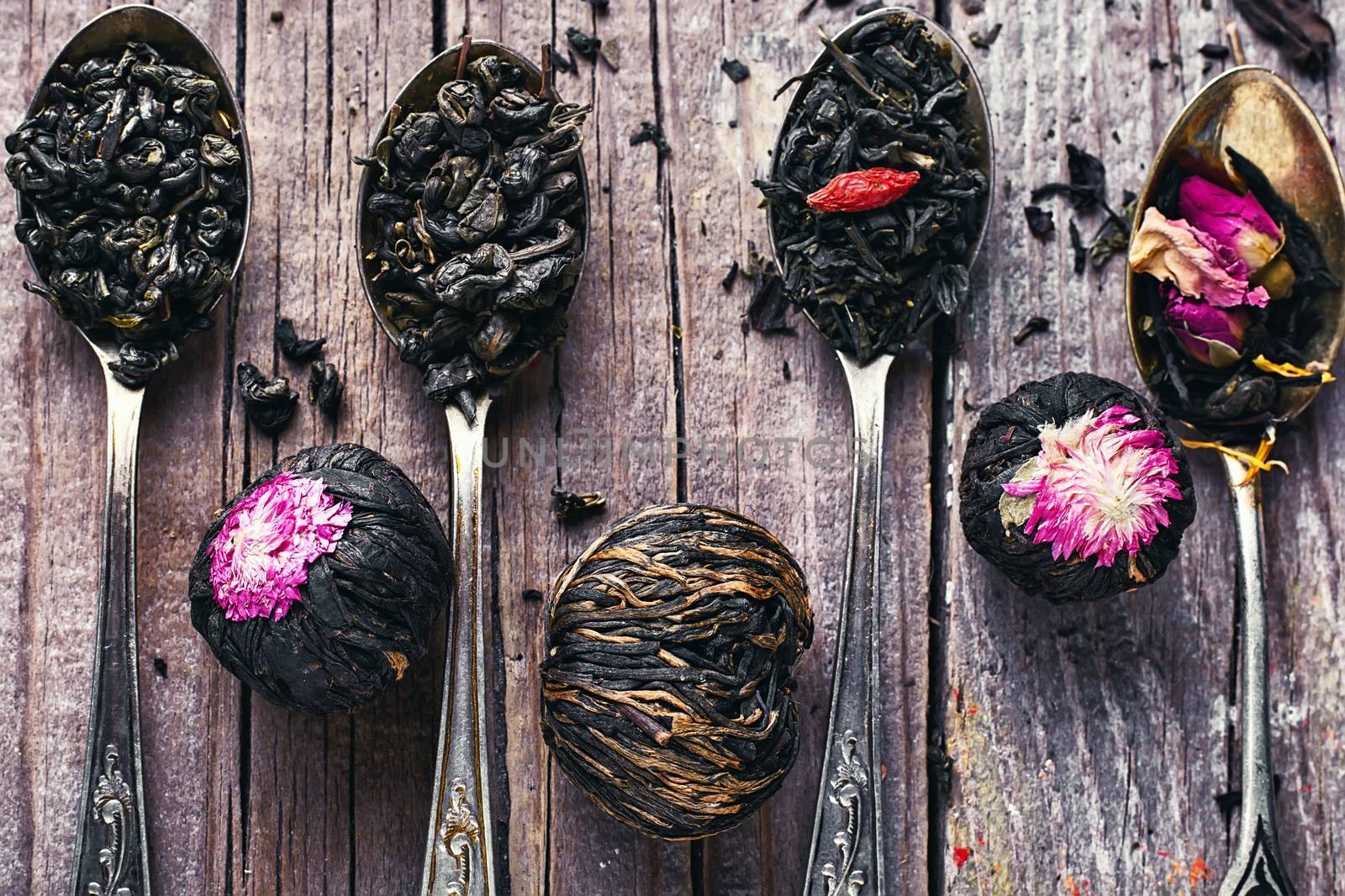 kinds of tea infuser in tea spoons on wooden background