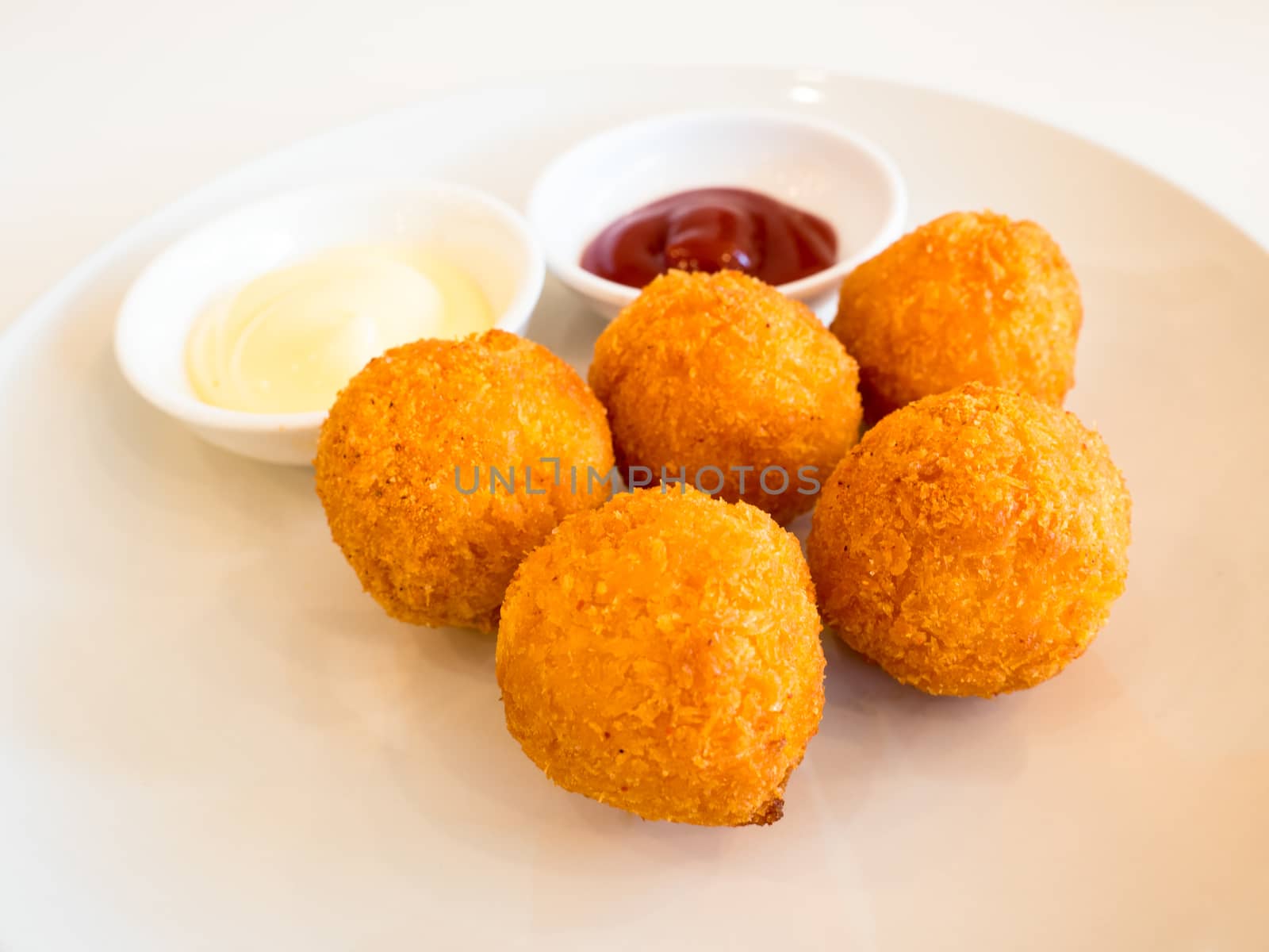 Deep fried cheese balls with sauce on white background by APTX4869