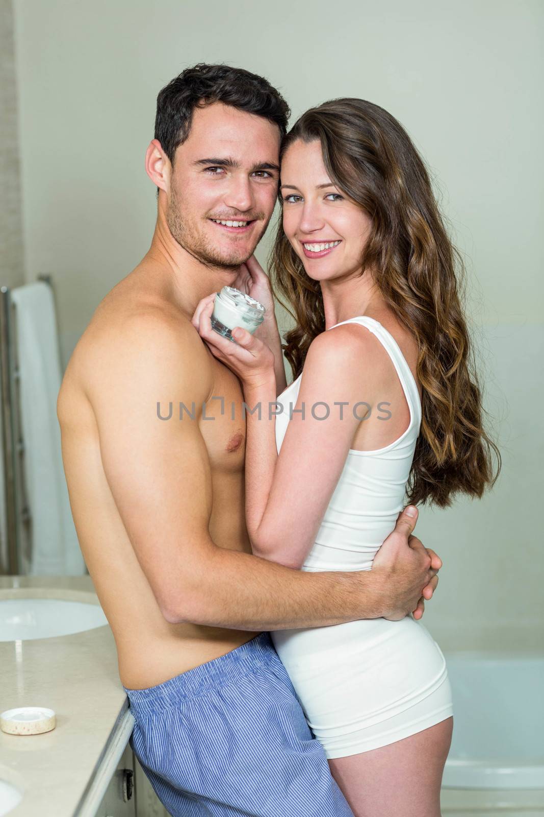 Portrait of romantic couple smiling and embracing in bathroom