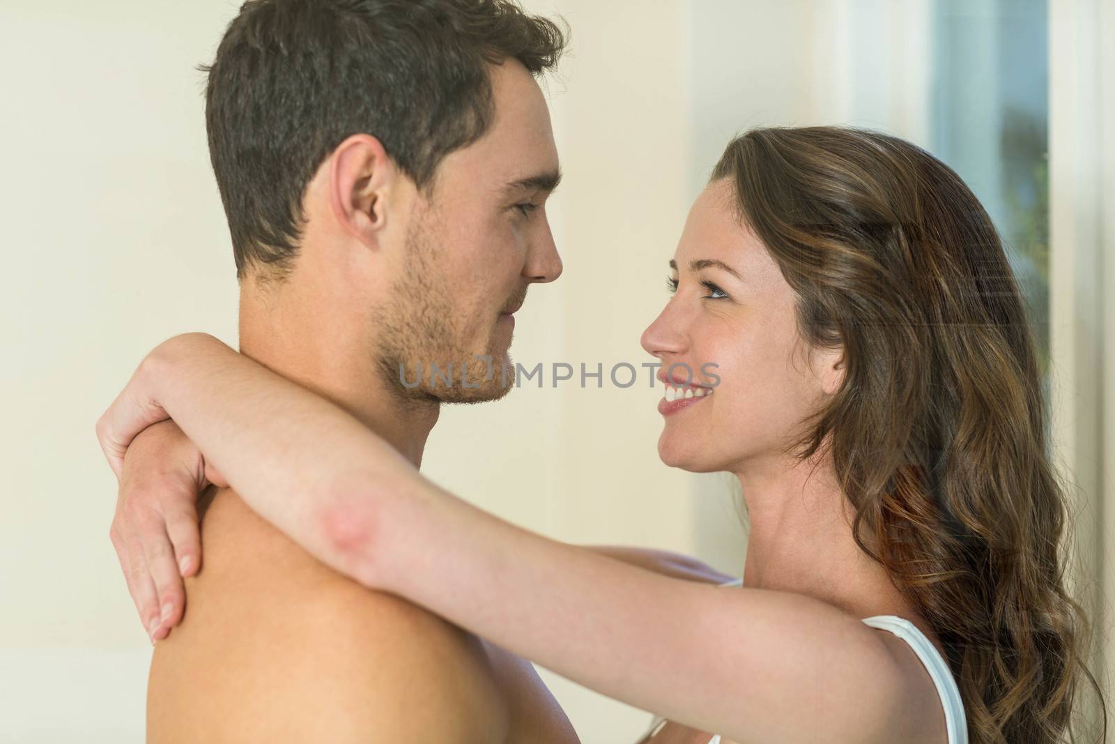 Romantic couple smiling and embracing in bathroom