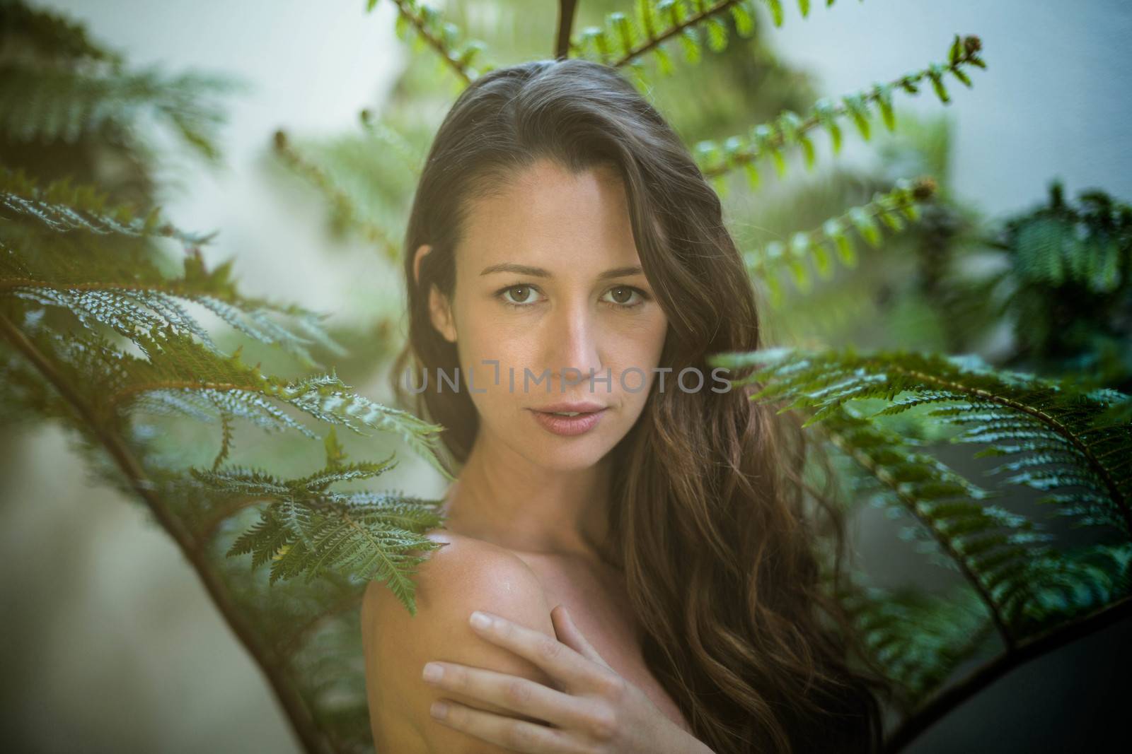 Beautiful woman standing outdoors against green plants