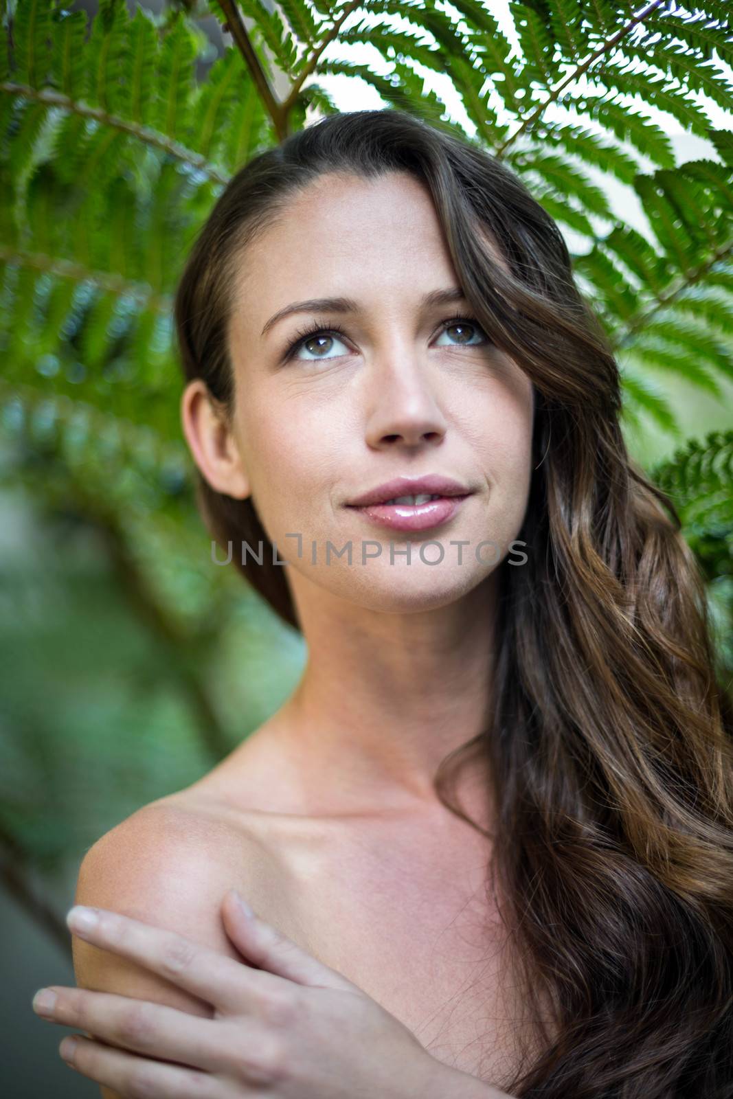 Beautiful woman standing outdoors against green plants