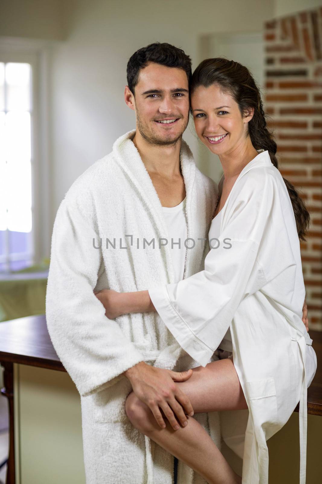 Portrait of romantic young couple cuddling each other in kitchen 