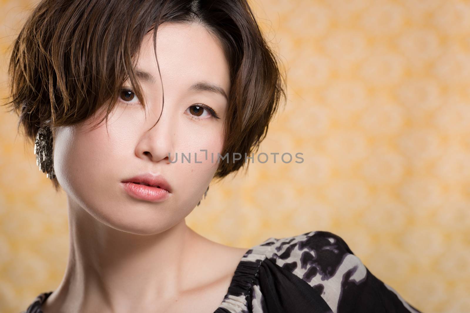A portrait of a  young and beautiful Japanese woman shot on a yellow and white lace background.